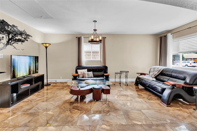 living room featuring a textured ceiling, plenty of natural light, and a notable chandelier