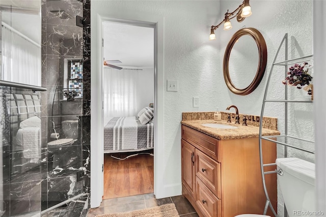 bathroom featuring tile patterned flooring, toilet, a shower, ceiling fan, and vanity