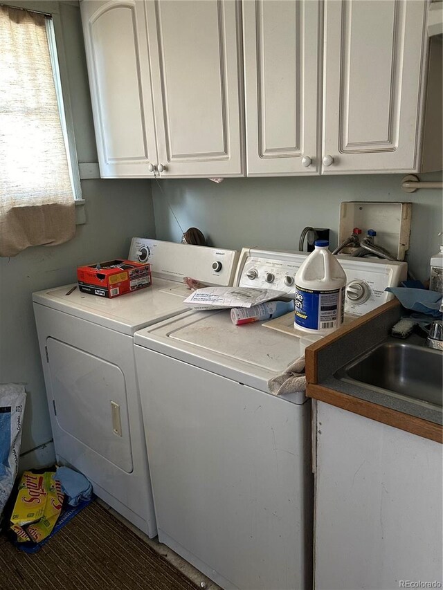 laundry area with sink, cabinets, and separate washer and dryer