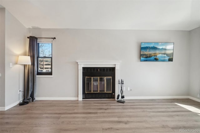 540 S Forest St Unit 3-204, Denver, CO 80246 - unfurnished living room with baseboards, a glass covered fireplace, and wood finished floors