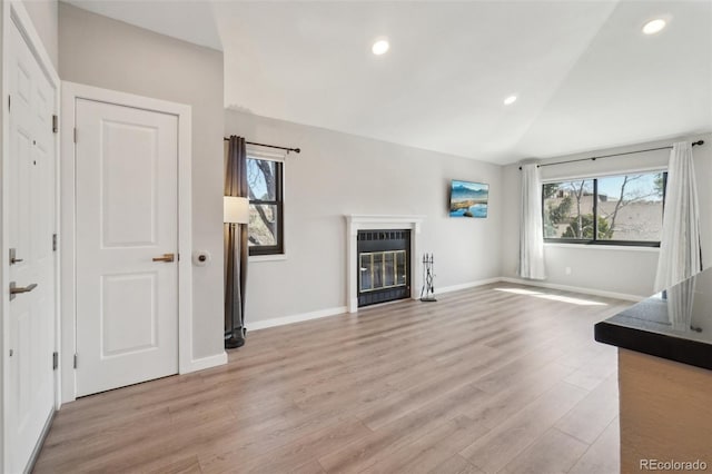 540 S Forest St Unit 3-204, Denver, CO 80246 - unfurnished living room featuring a fireplace with flush hearth, vaulted ceiling, baseboards, recessed lighting, and light wood-style flooring