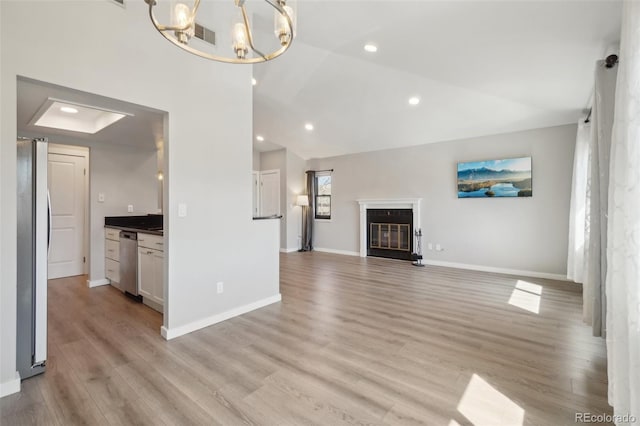 540 S Forest St Unit 3-204, Denver, CO 80246 - unfurnished living room featuring a glass covered fireplace, baseboards, light wood-style floors, recessed lighting, and a notable chandelier