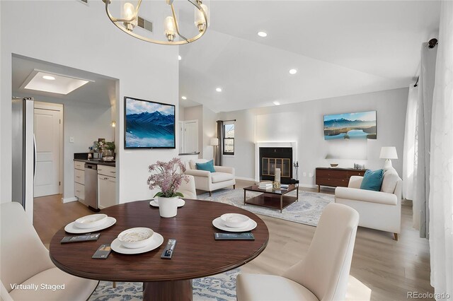 540 S Forest St Unit 3-204, Denver, CO 80246 - dining space featuring baseboards, a notable chandelier, light wood-style flooring, and lofted ceiling