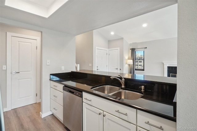 540 S Forest St Unit 3-204, Denver, CO 80246 - kitchen with dark countertops, light wood-type flooring, white cabinetry, a sink, and dishwasher
