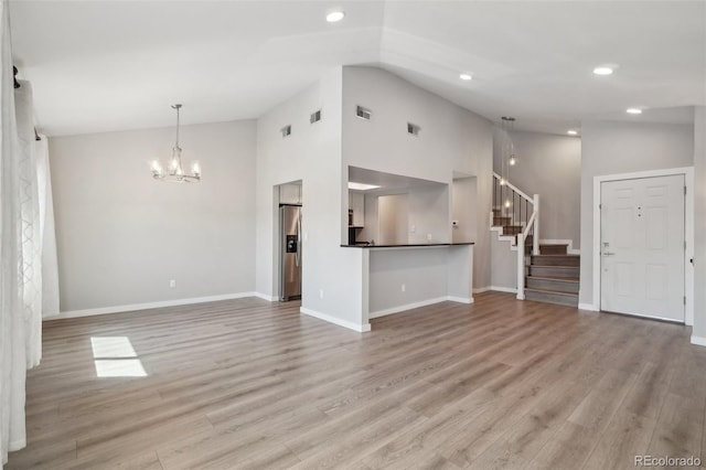 540 S Forest St Unit 3-204, Denver, CO 80246 - unfurnished living room with an inviting chandelier, baseboards, high vaulted ceiling, and stairway