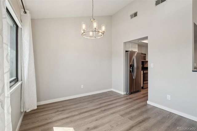 540 S Forest St Unit 3-204, Denver, CO 80246 - unfurnished dining area featuring an inviting chandelier, baseboards, light wood-style flooring, and visible vents