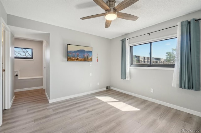 540 S Forest St Unit 3-204, Denver, CO 80246 - spare room with baseboards, a ceiling fan, light wood finished floors, and a textured ceiling