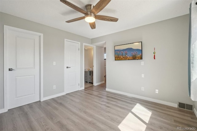 540 S Forest St Unit 3-204, Denver, CO 80246 - unfurnished bedroom featuring visible vents, connected bathroom, baseboards, and light wood-style floors