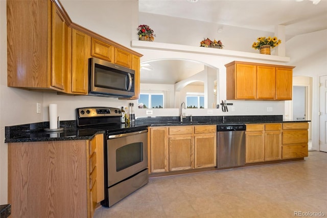 17950 Cumbres Rd, Peyton, CO 80831 - kitchen with appliances with stainless steel finishes, a sink, brown cabinets, dark stone counters, and light tile patterned floors