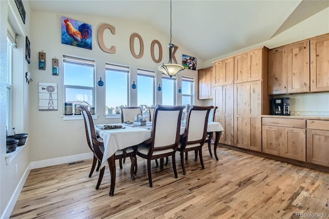 dining area featuring light hardwood / wood-style flooring and vaulted ceiling