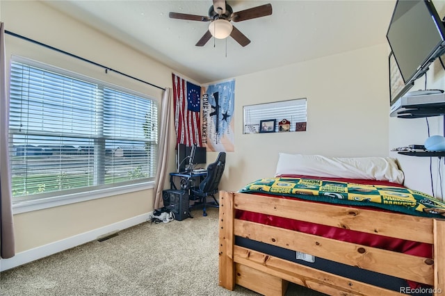 carpeted bedroom featuring multiple windows and ceiling fan