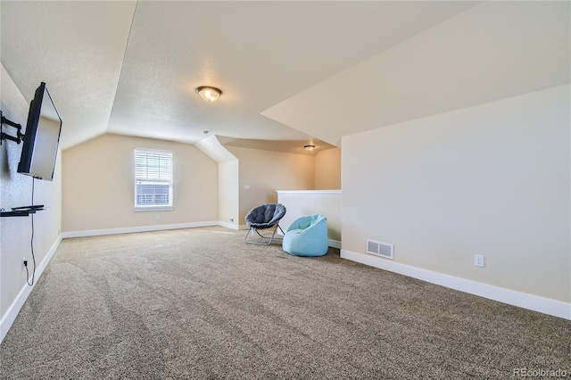 bonus room with vaulted ceiling, carpet, and a textured ceiling