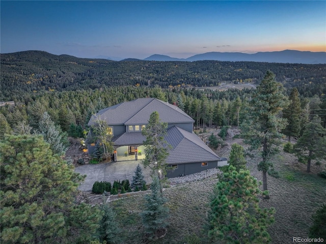 birds eye view of property with a mountain view and a forest view