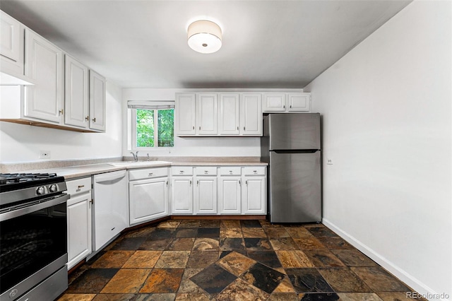 1535 Hudson St Unit 1, Denver, CO 80220 - kitchen with appliances with stainless steel finishes, stone tile floors, light countertops, white cabinetry, and a sink