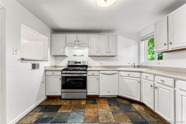 1535 Hudson St Unit 1, Denver, CO 80220 - kitchen featuring dishwasher, stainless steel gas stove, a sink, stone tile flooring, and white cabinetry
