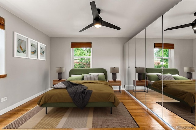 1535 Hudson St Unit 1, Denver, CO 80220 - bedroom featuring multiple windows, light wood-style floors, baseboards, and ceiling fan