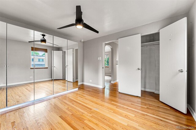 1535 Hudson St Unit 1, Denver, CO 80220 - unfurnished bedroom featuring arched walkways, light wood-style flooring, baseboards, and a ceiling fan