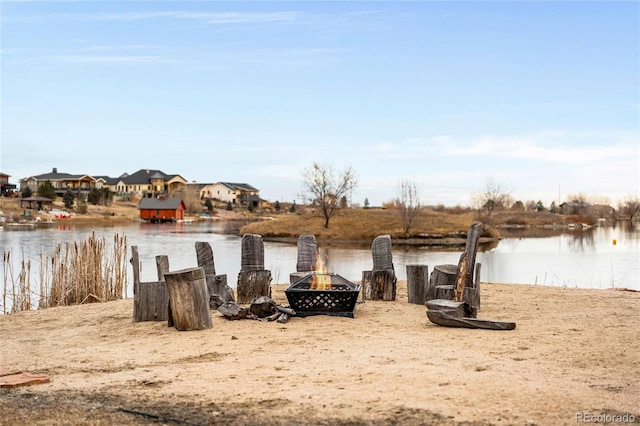 dock area with a water view and an outdoor fire pit