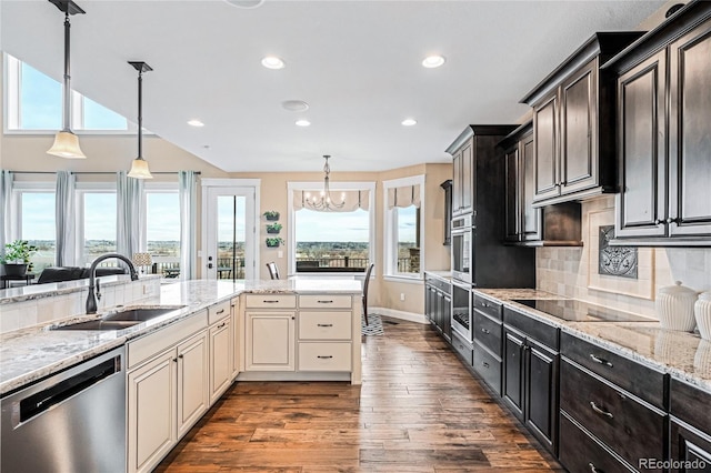 kitchen featuring dark wood-type flooring, sink, tasteful backsplash, appliances with stainless steel finishes, and cream cabinetry