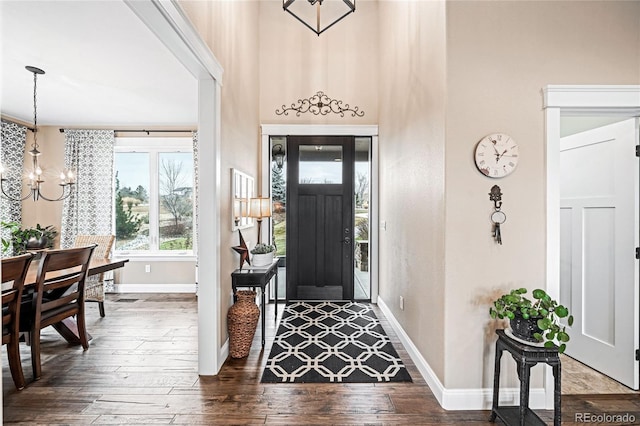 foyer entrance featuring dark hardwood / wood-style flooring, a high ceiling, and a notable chandelier