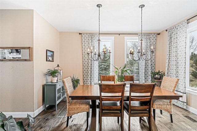 dining area with an inviting chandelier and hardwood / wood-style flooring