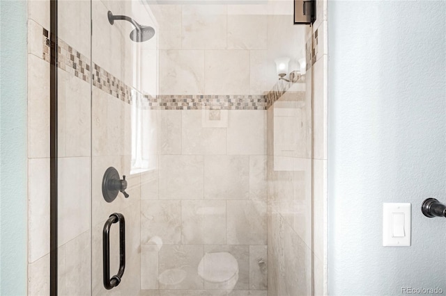 bathroom featuring an enclosed shower and toilet