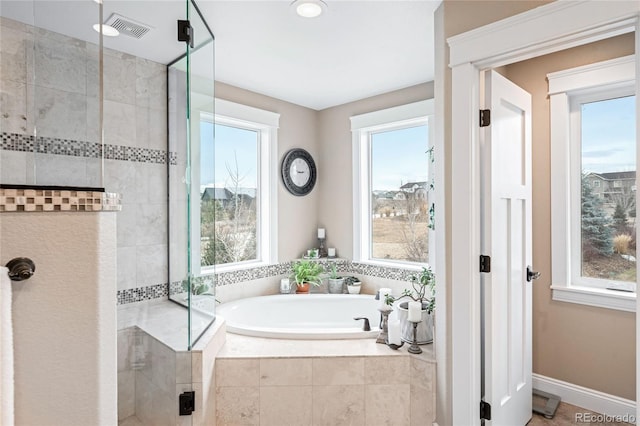 bathroom featuring plus walk in shower and a healthy amount of sunlight