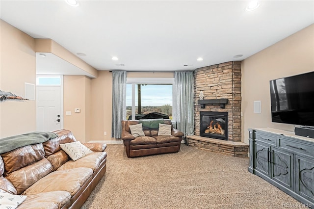 living room with a stone fireplace and light colored carpet