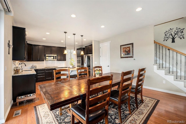 6173 Eldora St, Golden, CO 80403 - dining space featuring light wood-style flooring, recessed lighting, baseboards, and stairway