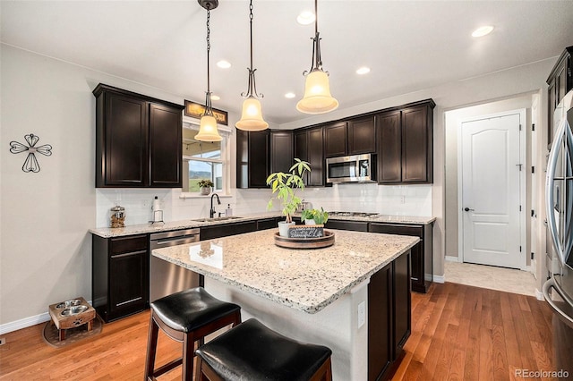 6173 Eldora St, Golden, CO 80403 - kitchen with stainless steel appliances, a sink, backsplash, light stone counters, and baseboards