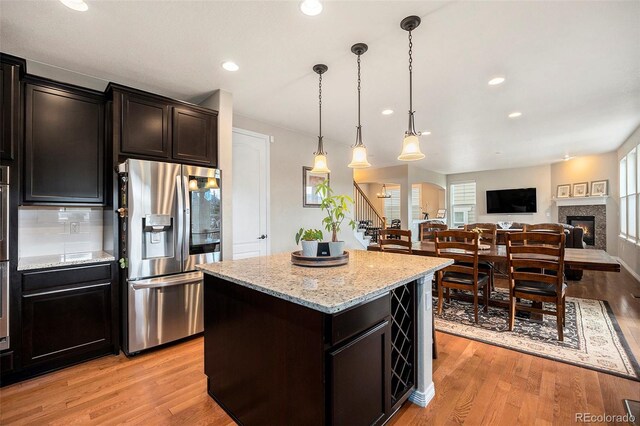 6173 Eldora St, Golden, CO 80403 - kitchen with stainless steel fridge with ice dispenser, a kitchen island, light wood-style flooring, and recessed lighting