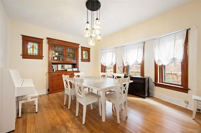 1430 Monroe St, Denver, CO 80206 - dining room with light wood-style flooring, plenty of natural light, a chandelier, and baseboards