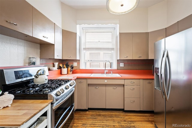 1430 Monroe St, Denver, CO 80206 - kitchen with stainless steel appliances, a sink, wood finished floors, and tasteful backsplash