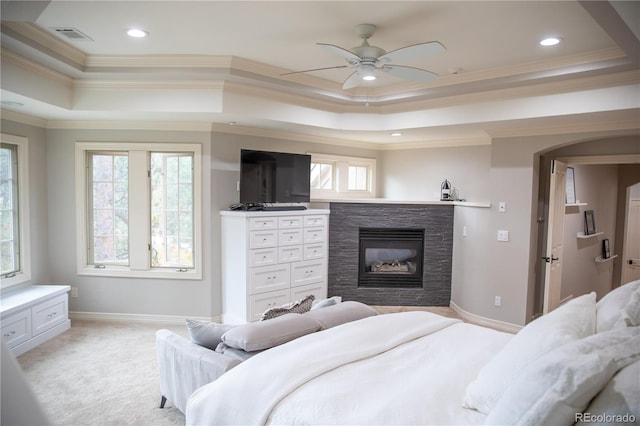 bedroom with crown molding, a raised ceiling, multiple windows, and ceiling fan