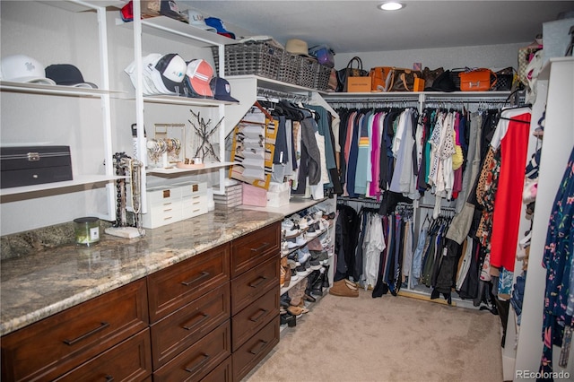 spacious closet featuring light colored carpet