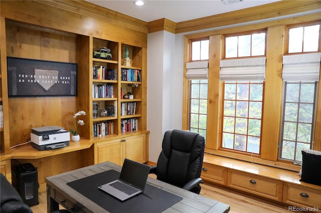 office with built in desk, crown molding, and light hardwood / wood-style flooring