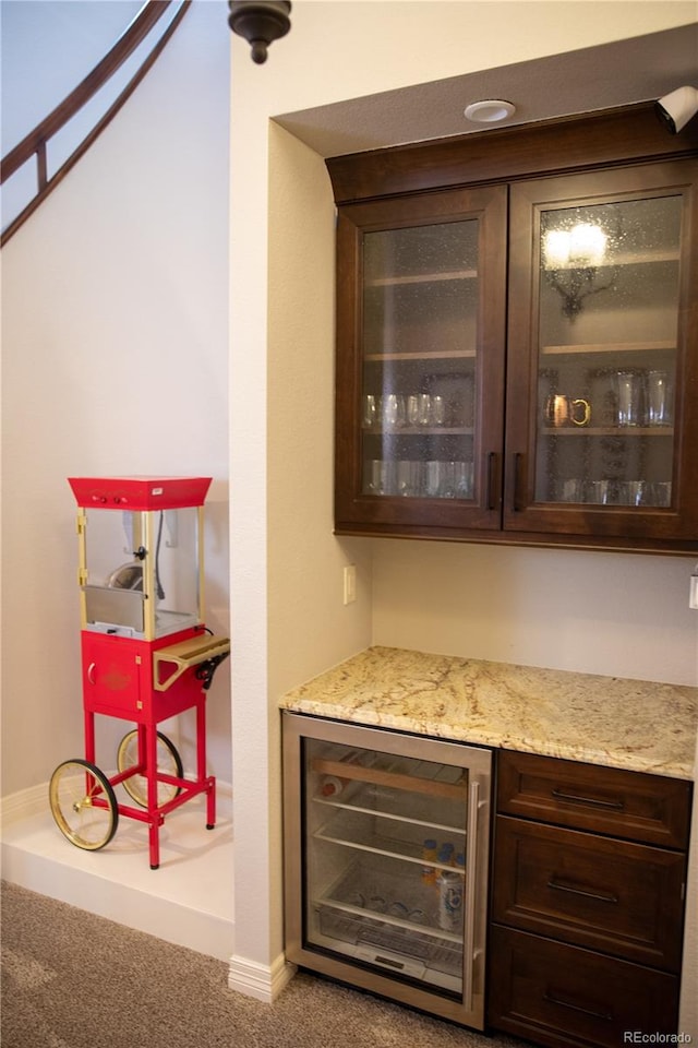 bar with wine cooler, carpet, and dark brown cabinets