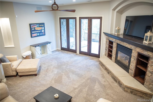 living room with a ceiling fan, a stone fireplace, baseboards, carpet flooring, and recessed lighting