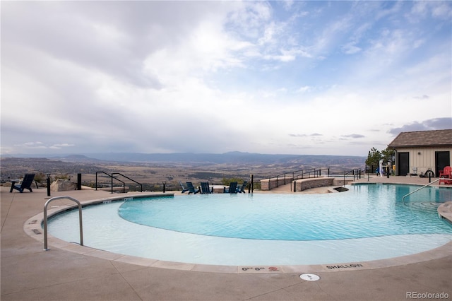 view of swimming pool with a mountain view and a patio area