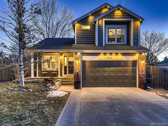 traditional home featuring a garage, roof with shingles, fence, and driveway