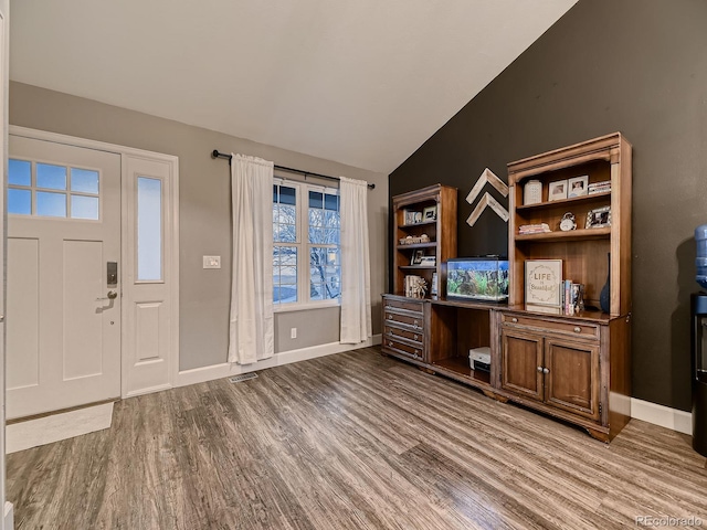 entryway featuring dark wood-style floors, lofted ceiling, visible vents, and baseboards