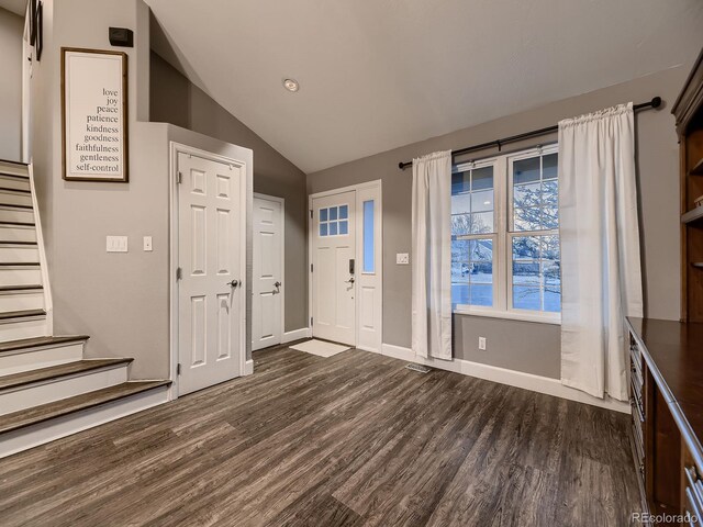 foyer with vaulted ceiling, dark wood-style flooring, stairway, and baseboards