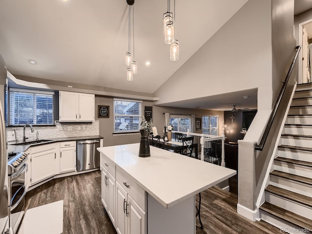 kitchen with stainless steel appliances, a breakfast bar, dark wood-style flooring, white cabinets, and pendant lighting