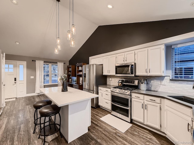 kitchen with stainless steel appliances, a center island, white cabinetry, and a sink