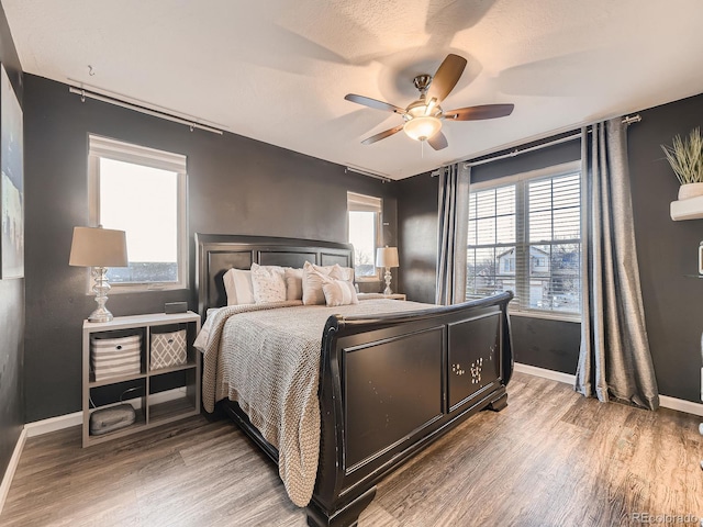 bedroom featuring baseboards, a ceiling fan, and light wood-style floors