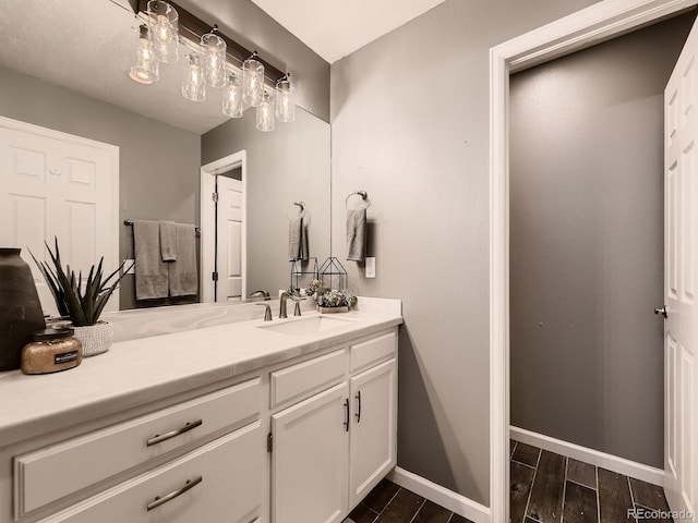 bathroom featuring wood tiled floor, baseboards, and vanity