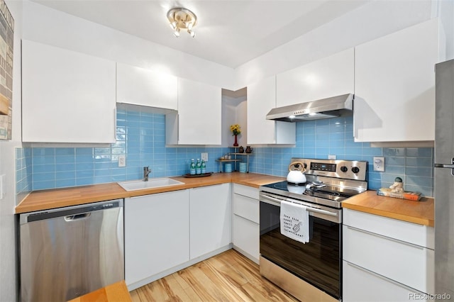 kitchen featuring stainless steel appliances, a sink, extractor fan, and white cabinets