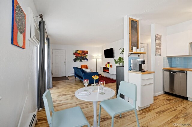 dining area featuring light wood-style floors and a baseboard heating unit