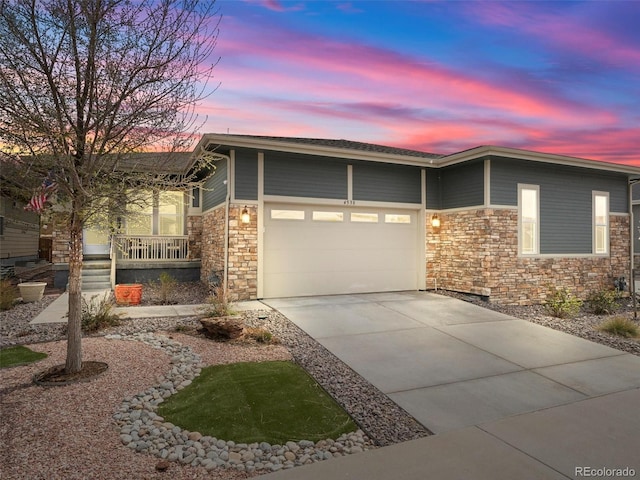 4538 Hidden Gulch Rd, Castle Rock, CO 80104 - view of front facade featuring concrete driveway, stone siding, a porch, and an attached garage
