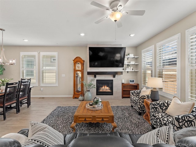 4538 Hidden Gulch Rd, Castle Rock, CO 80104 - living room with ceiling fan with notable chandelier, recessed lighting, light wood finished floors, a premium fireplace, and baseboards